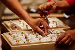 A salesperson shows a gold ring to customers at a jewellery showroom in Ahmedabad, India, October 8, 2025. REUTERS/Amit Dave 