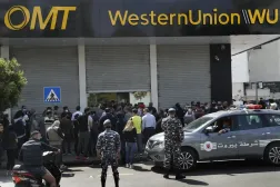 Lebanese citizens queue outside a Western Union shop to receive their money transfers. AP file photo
