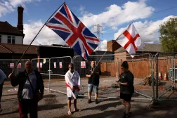 FILE PHOTO: Protesters hold the Union Jack and St George's flags outside the Bell Hotel in Essex after the British government challenged a court ruling requiring asylum seekers to be temporarily evicted from the hotel in Epping, Britain, August 29, 2025. REUTERS/Jack Taylor/File Photo