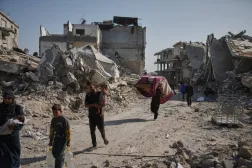 Filistinliler, Gazze Şeridi'ndeki Cibaliye'de yıkımın ortasında yürüyor (AP)