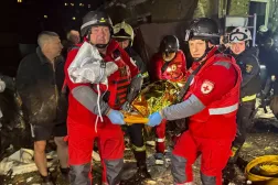 Rus hava saldırılarının Harkiv'i hedef almasının ardından sağlık görevlileri bir kurbanın cesedini taşıyor (Reuters)