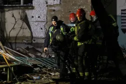 Kurtarma ekipleri, Rus saldırılarının ardından Kiev'deki bir konut binasının içinde öldürülen bir sakinin cesedini taşıyor (Reuters)