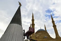 Beyrut'un merkezindeki Muhammed el-Emin Camii'nin önüne Noel ağacı süslerini asmak için vinç kullanan işçiler (EPA)