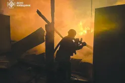 This handout photograph taken and released by the State Emergency Service of Ukraine on December 6, 2025, shows a firefighter extinguishing a fire at a site of an air attack in Kyiv region, amid the Russian invasion of Ukraine. (Photo by Handout / STATE EMERGENSY SERVICE OF UKRAINE / AFP)  