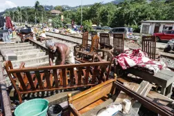 A Sri Lankan flood victim sorts out his belongings by railway tracks in Kandy. The authorities have issued fresh landslide warnings as monsoon storms make hillsides unstable. AFP
