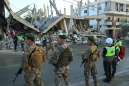 Lebanese soldiers stand in front of a building targeted by an Israeli airstrike in the village of Deir Kifa in south Lebanon last month. (AFP file) 