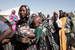 FILE - Women displaced from El-Fasher stand in line to receive food aid at the newly established El-Afadh camp in Al Dabbah, in Sudan's Northern State, Nov. 16, 2025. (AP Photo/Marwan Ali, File)
