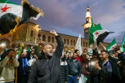 Syrians shout slogans and wave flags outside the Umayyad Mosque before a prayer held ahead of celebrations marking the first anniversary of the ousting of the Bashar al-Assad regime in Damascus, Syria, Monday, Dec. 8, 2025. (AP) 