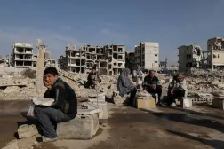 People sit after receiving bread from Ecir Kapici, Turkish humanitarian NGO at Al-Yarmouk Palestinian refugee camp, after Syria's Bashar Al-Assad was ousted, in Damascus, Syria, December 20 , 2024. (Reuters)
