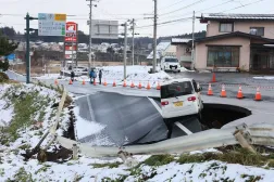 A car is stranded on a collapsed road in Tohoku, Aomori prefecture, northeastern Japan, 09 December 2025. (EPA/Jiji Press)