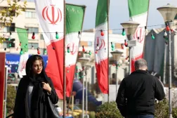 Iranians walk past Iran's national flag on a street in Tehran, Iran, 10 December 2025. (EPA)