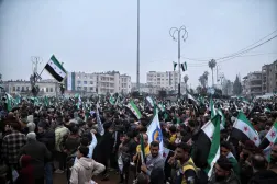 People gather during a march marking the first anniversary of the overthrow of Bashar al-Assad’s regime in Idlib (EPA)