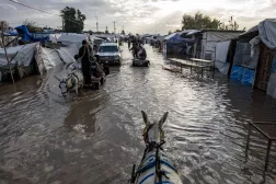 Displaced Palestinians make their way on animal-drawn carts through a flooded street following heavy rainfall in Khan Younis in southern Gaza, 11 December 2025. EPA/HAITHAM IMAD