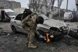 ضابط شرطة يُطفئ سيارة محترقة في موقع غارة جوية روسية بطائرة مسيَّرة وسط الهجوم على أوكرانيا في زابوروجيا (رويترز)