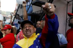 أحد مؤيدي الحكومة يلوّح بيده خلال احتجاج على احتجاز الولايات المتحدة ناقلة نفط فنزويلية في كاراكاس (رويترز)