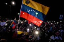 Supporters of Venezuela's President Nicolas Maduro wave a Venezuelan flag during a rally demanding peace in Caracas on December 15, 2025. (Photo by Juan BARRETO / AFP)