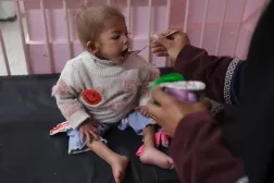 Şiddetli yetersiz beslenmeden muzdarip Gazzeli kız Acvan, dün Han Yunus'taki el-Nasır Hastanesi'nde annesinden yiyecek alıyor (Reuters)