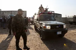 عناصر من «الحشد الشعبي» يجلسون في سيارة بعد هجوم أميركي على مقر «النجباء» ببغداد في 4 يناير 2024 (رويترز)