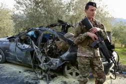 عنصر من الجيش اللبناني يقف قرب سيارة مستهدفة في بلدة عقتنيت بقضاء الزهراني استهدفتها غارة إسرائيلية الثلاثاء (إ.ب.أ)