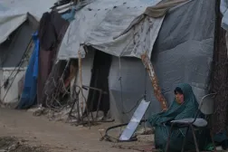 A woman sits next to her tent on an alley of a makeshift tent camp for displaced Palestinians in Deir al-Balah, central Gaza Strip, Tuesday, Dec. 23, 2025. (AP Photo/Abdel Kareem Hana)