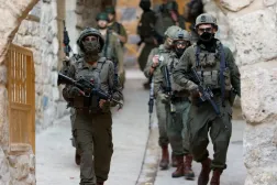 İsrail askerleri, Batı Şeria'daki yerleşimcilere yönelik haftalık ziyaret sırasında yürüyüş yapıyor (Reuters)