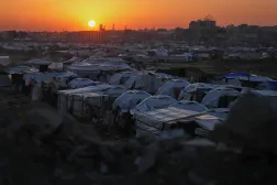 The sun sets behind a makeshift tent camp for displaced Palestinians set up in an area of al-Bureij camp, in the central Gaza Strip, Wednesday, Dec. 24, 2025. (AP)