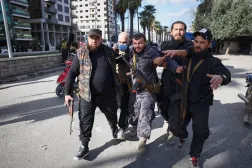 إبعاد ضابط شرطة مصاب عن منطقة الاحتجاجات في اللاذقية (أ.ب)