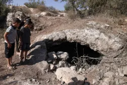 صبية فلسطينيون ينظرون إلى كهف قُتل فيه 3 شبان على يد القوات الإسرائيلية قرب مدينة جنين بالضفة الغربية أكتوبر الماضي (أ.ف.ب)