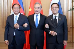 This handout photo taken and released by Agence Kampuchea Press (AKP) on December 29, 2025 shows China's Foreign Minister Wang Yi (C), Cambodia's Deputy Prime Minister Prak Sokhonn (L), who is also the country's Foreign Minister, and Thailand's Foreign Minister Sihasak Phuangketkeow (R) linking arms during a meeting in China's Yunnan province. (Handout / Agence Kampuchea Press (AKP) / AFP) 