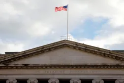 العلم الأميركي يرفرف فوق مبنى وزارة الخزانة في واشنطن (رويترز)