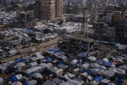Palestinians walk along streets past tent camps for displaced people in Gaza City, Wednesday, Dec. 31, 2025. (AP)