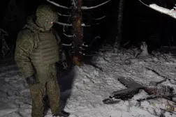 A Russian service member stands next to the remains of a drone, which, according to the Russian Defense Ministry, was downed during the repelling of an alleged Ukrainian attack on the Russian presidential residence in the Novgorod Region, in an unknown location in Russia, in this still image from a video released December 31, 2025. (Russian Defense Ministry/Handout via Reuters)