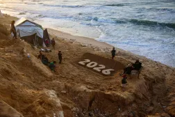 منحوتة رملية للفنان يزيد أبو جراد تمثل العام المقبل حيث يستعد الفلسطينيون النازحون لاستقبال العام الجديد في دير البلح بوسط قطاع غزة (أ.ف.ب)