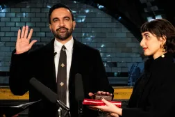 ممداني لدى أدائه القسم على نسخة من المصحف حملتها زوجته في نيويورك أمس (رويترز)