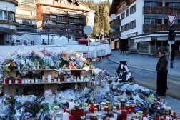  A woman looks at tributes placed outside the "Le Constellation" bar, after a deadly fire and explosion during a New Year's Eve party in the upscale ski resort of Crans-Montana in southwestern Switzerland, January 4, 2026. (Reuters)