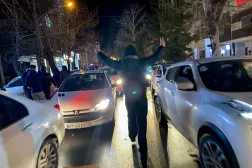Hamedan'daki gösteriler sırasında trafik yavaşlarken bir protestocu zafer işaretleri yapıyor (AFP- Getty)