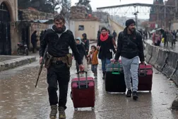 TOPSHOT - Residents of Aleppo's Sheikh Maqsud area evacuate their neighborhood after warnings from the Syrian army that called on civilians to get out of harms way, following the refusal of Kurdish fighter forces to leave Aleppo, on January 9, 2026. (Photo by OMAR HAJ KADOUR / AFP)
