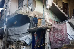 طفلة فلسطينية تنظر من مبنى مدمر في جباليا بشمال قطاع غزة (رويترز)