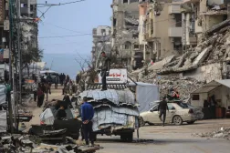 فلسطينيون يشقون طريقهم وسط المباني المتضررة جراء الحرب في جباليا بشمال قطاع غزة (أ.ف.ب)