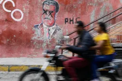 A motorcyclist rides past graffiti depicting former Venezuelan President Nicolas Maduro, who is facing trial in the United States after US forces captured him, in Caracas, Venezuela, Sunday, Jan. 11, 2026. (AP)