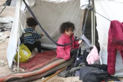 أطفال فلسطينيون يحتمون بخيام دمرتها الأمطار في مخيم النصيرات بقطاع غزة (د.ب.أ)