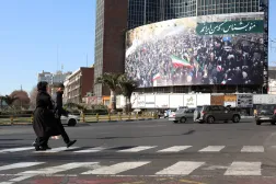 إيرانيون يسيرون في أحد شوارع طهران (إ.ب.أ)