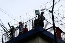 Guatemala'daki üç hapishanede isyanlar patlak verirken, Renovación hapishanesindeki mahkumlar gözetleme kulesinde toplandı (Reuters)