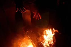 Local residents gather around a bonfire during an outdoor party to keep warm as many apartments remain without heating in Kyiv on January 18, 2026, amid the Russian invasion of Ukraine. (AFP)