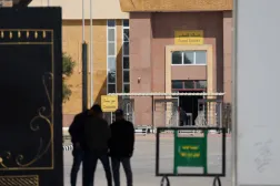People stand at the gate of the border crossing between Egypt and the Gaza Strip, in Rafah, Egypt, February 11, 2025. REUTERS/Amr Abdallah Dalsh