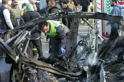 Lübnan'ın güneyindeki ez-Zehrani bölgesinde İsrail hava saldırısının hedef aldığı bir arabanın enkazını inceleyen sivil savunma gönüllüsü (AFP)