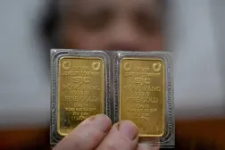 Vietnam'ın başkenti Hanoi'de elinde altın külçeleri tutan bir kadın (AFP)