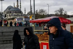 People walk past the counter of a traditional Turkish bagel "simit" street vendor, Eminönü, Istanbul, Türkiye, Dec. 27, 2025. (AFP)