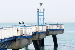 People cast their fishing rods on a pier in Kuwait City on January 31, 2026. (Photo by YASSER AL-ZAYYAT / AFP)