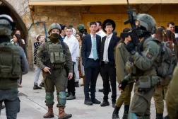 İsrailli yerleşimciler, işgal altındaki Batı Şeria'da bulunan Hebron'da 31 Ocak 2026'da haftalık devriye sırasında nöbetteki İsrail askerlerini izliyor (Reuters)